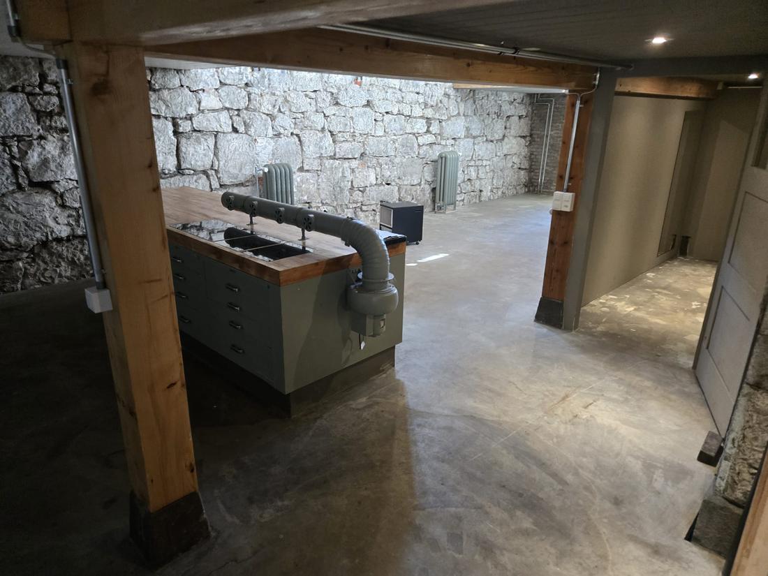 Die Kücheninsel mit Massivholzplatte vor der Bruchsteinwand
